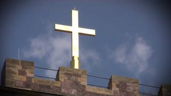 Ein Kreuz vor dunklen Wolken