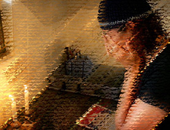 Eine Jüdin zündet zwei Sabbatkerzen an